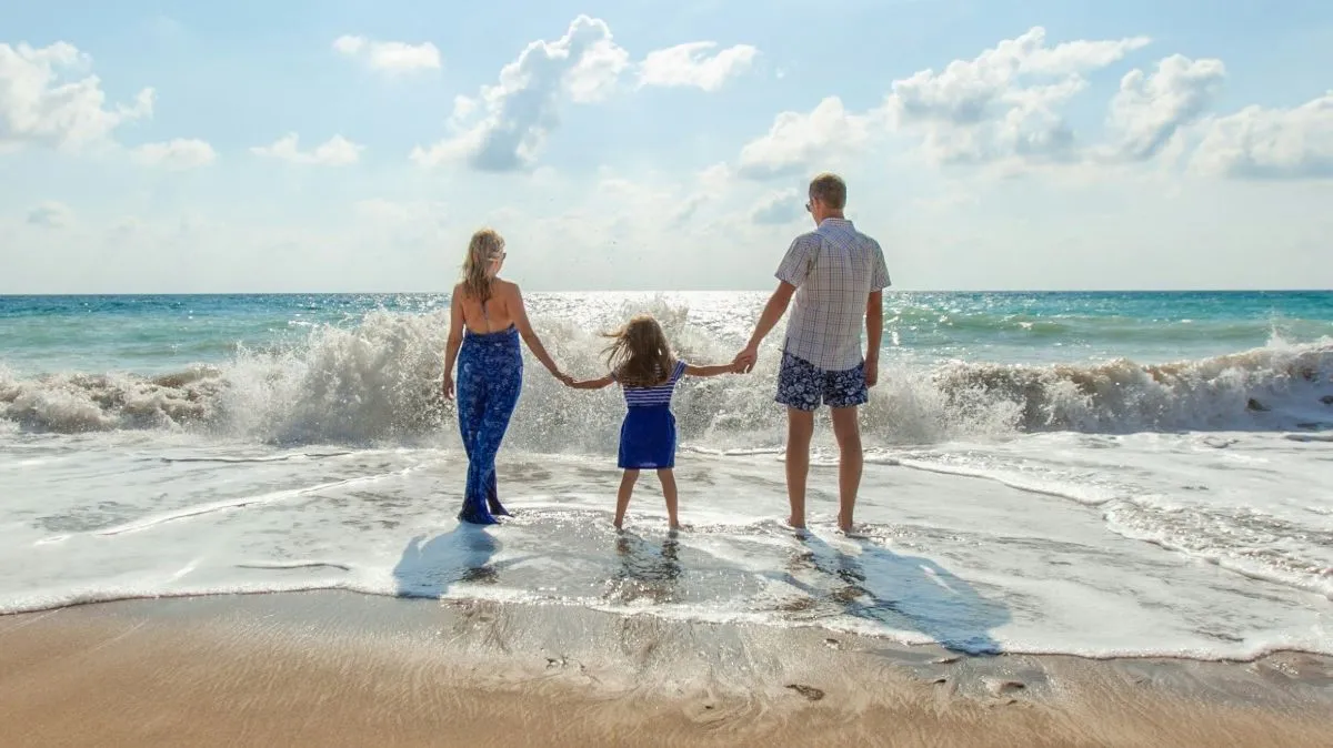 Família de mãos dadas na beira do mar