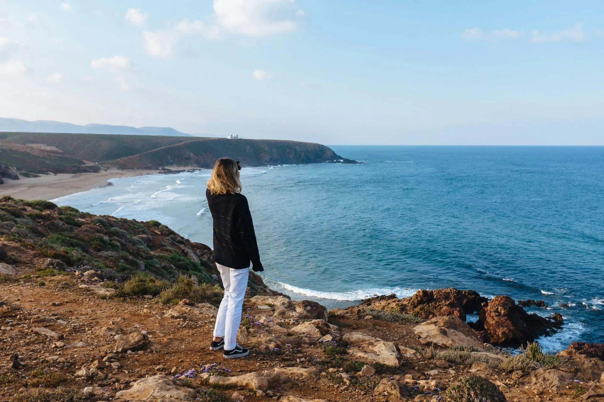 Viajante em um costão olhando o mar